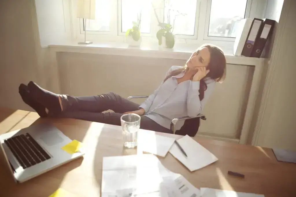 entrepreneurs breakentrepreneur break, Young business woman sitting at her desk in office with her legs on the desk. Caucasian female relaxing and looking up in home office.